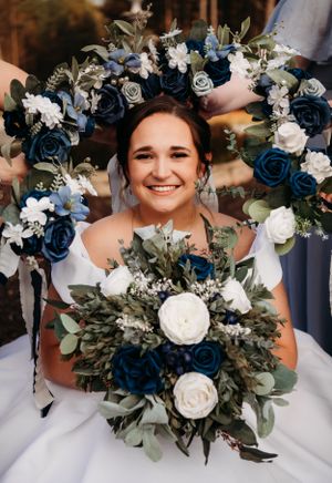 A radiant bride surrounded by a stunning blue and white floral arch.