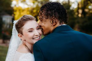 A tender wedding moment captured in warm sunset lighting.