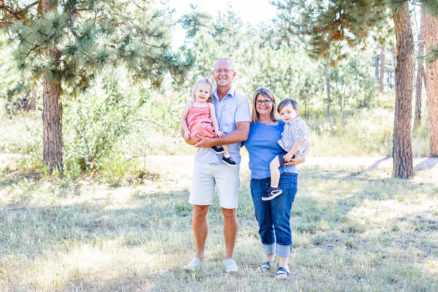 Grandparents hold their two toddler grandchildren in Black Forest, Colorado.