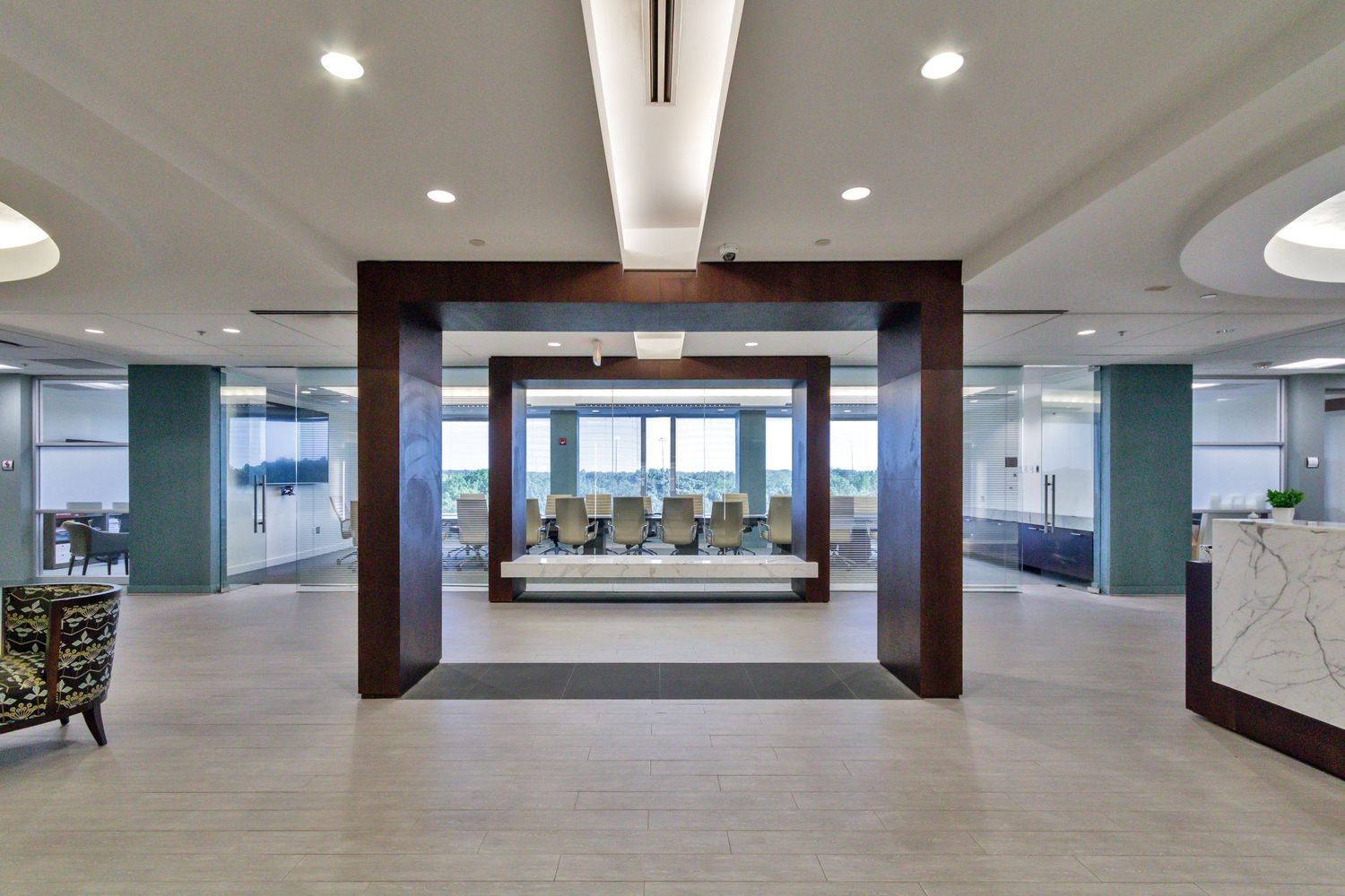 Modern office interior with wooden archway leading to a conference room with waterfront views.