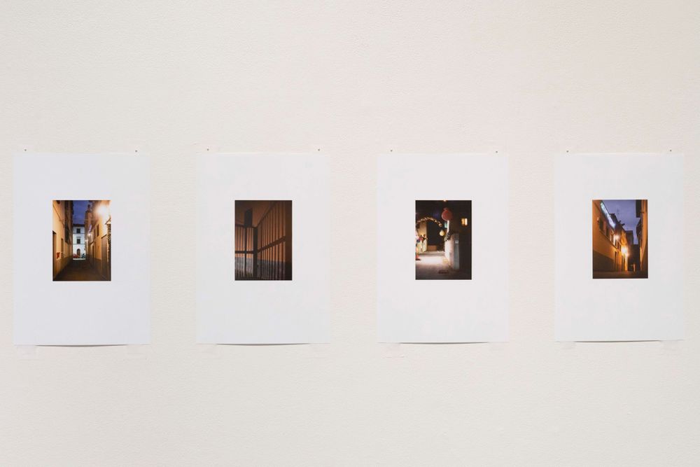 A series of four small photographs arranged horizontally on a white wall displaying architectural details and lighting.