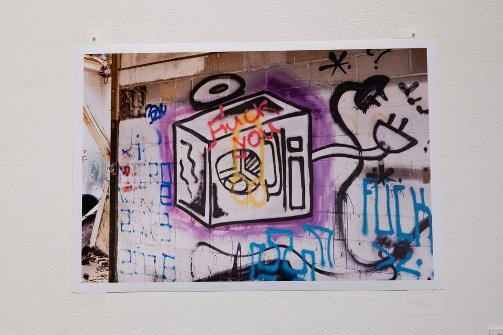 Long panoramic view of graffiti murals with blue and black spray paint designs.