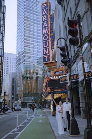 Urban wedding photo shoot on city street with vintage theater signs.