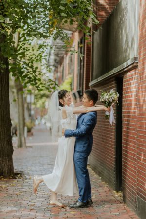 Romantic wedding portraits against brick walls in an urban alleyway.