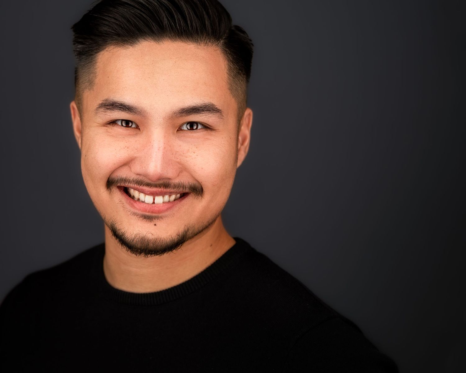 Professional headshots against dark background showing warm smiles and black attire.