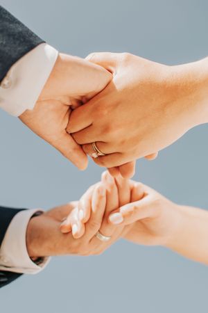 Multiple close-up shots of hands joining together against blue background.