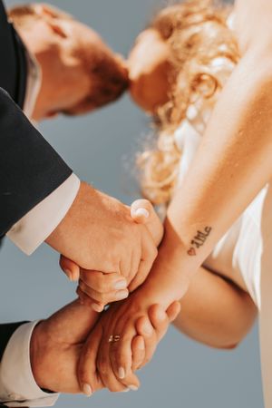 Artistic series of hands clasping together showing wedding rings.