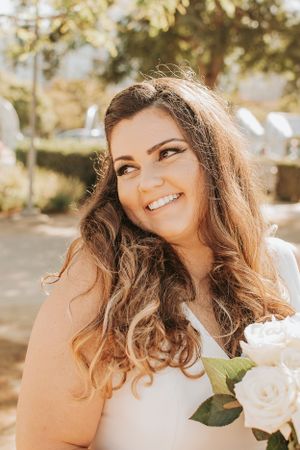Candid bridal portraits with white roses in warm sunlight.
