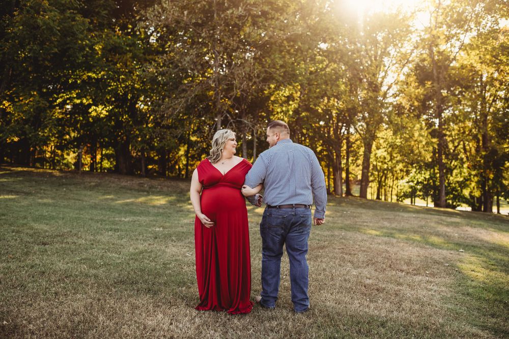 A couple shares an intimate moment in a park during golden hour photography session.