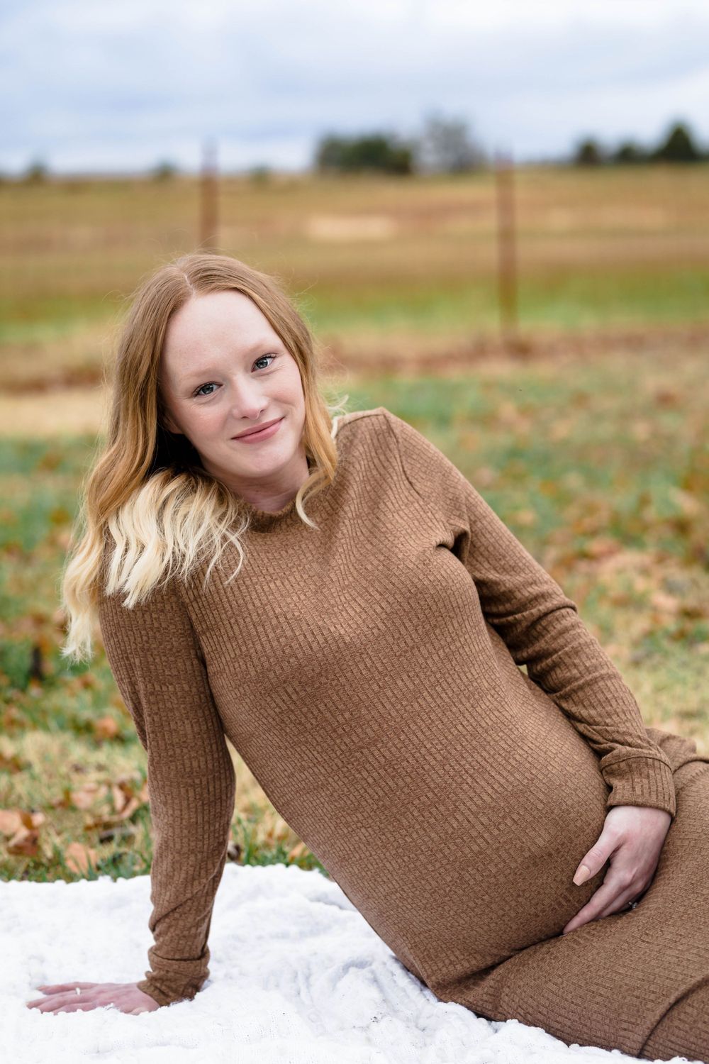 Expectant mother in a brown dress during an outdoor maternity session near Mountain Home, Arkansas
