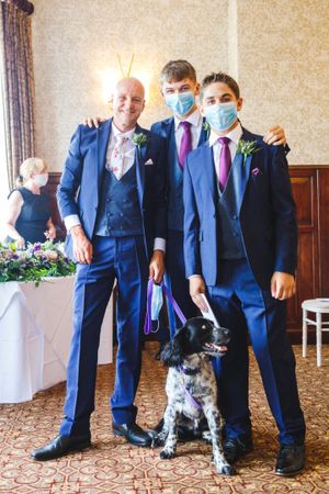 Groom, best man and usher with pet dog at civil ceremony in a Cheshire wedding