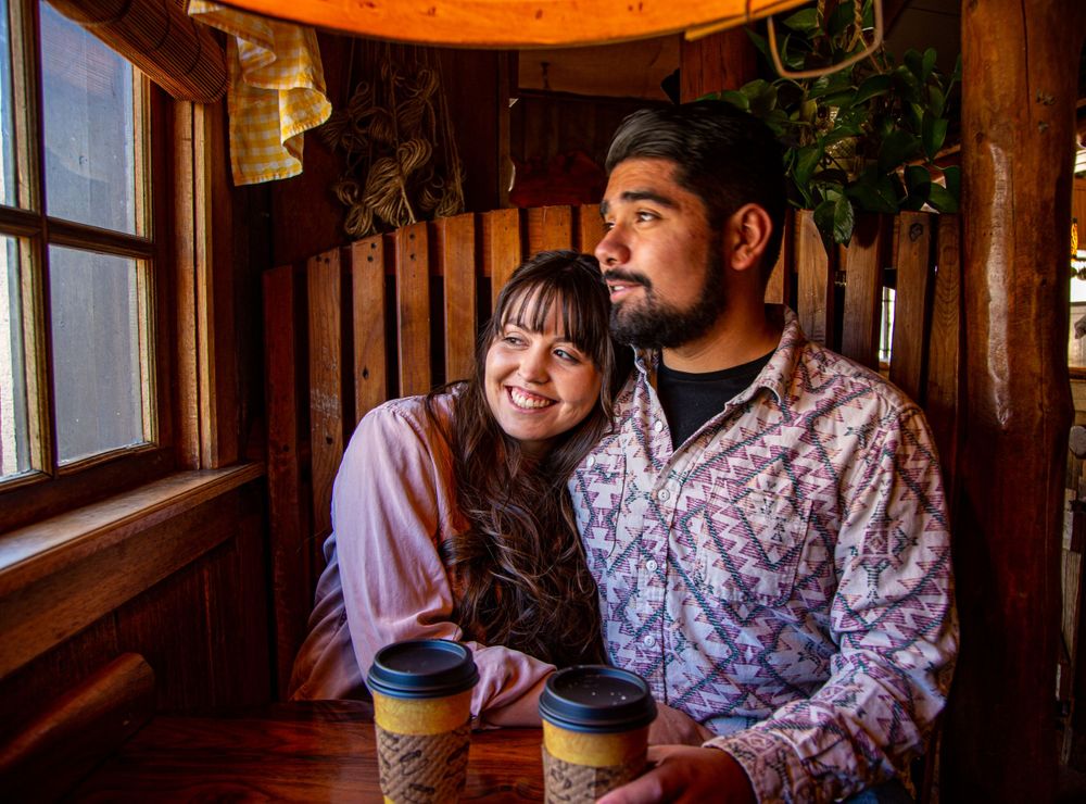Cozy coffee date inside rustic wooden cabin with window light.