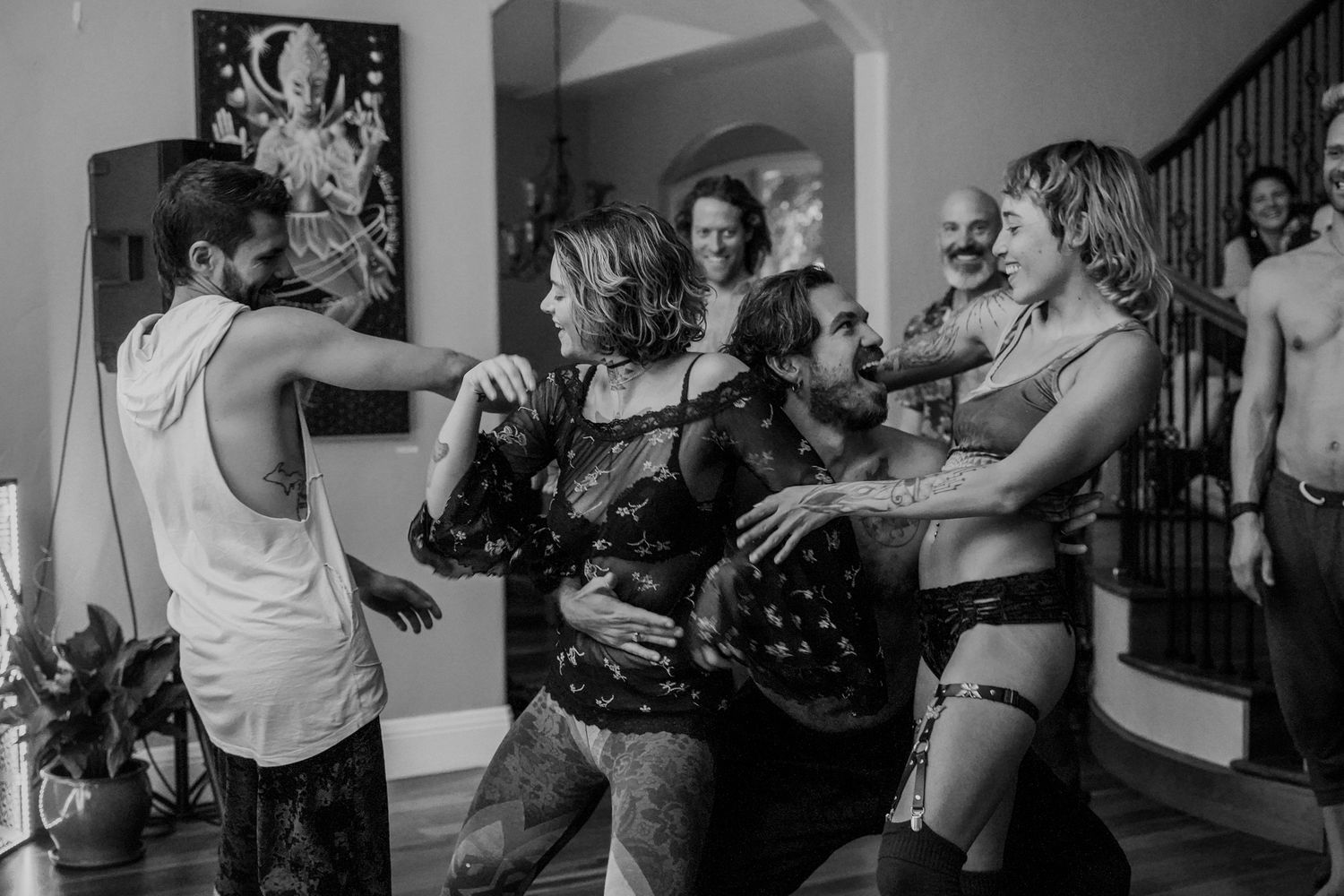 People dancing and celebrating at an indoor party in black and white photography.