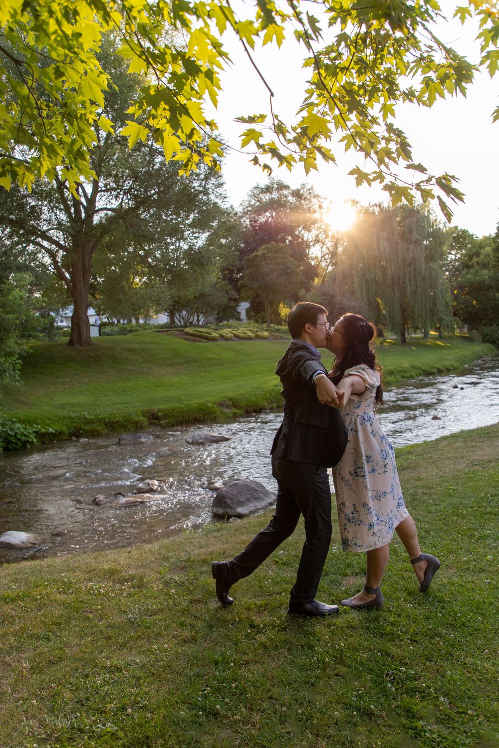 a couple standing face to face with their arms stretched out wide like airplanes while holding hands