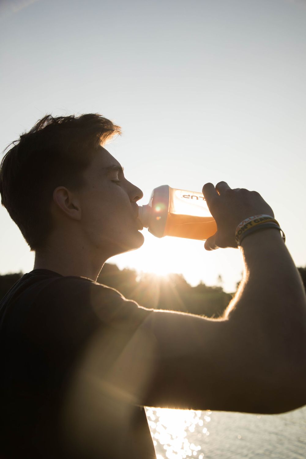 Imagefoto Mann trinkt aus LevlUp Becher im Sonnenuntergang