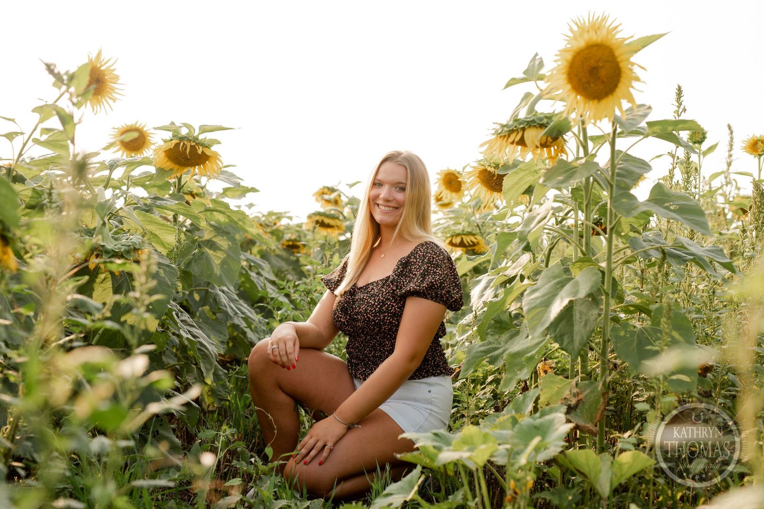 A joyful summer portrait surrounded by tall sunflowers in warm evening sunlight.