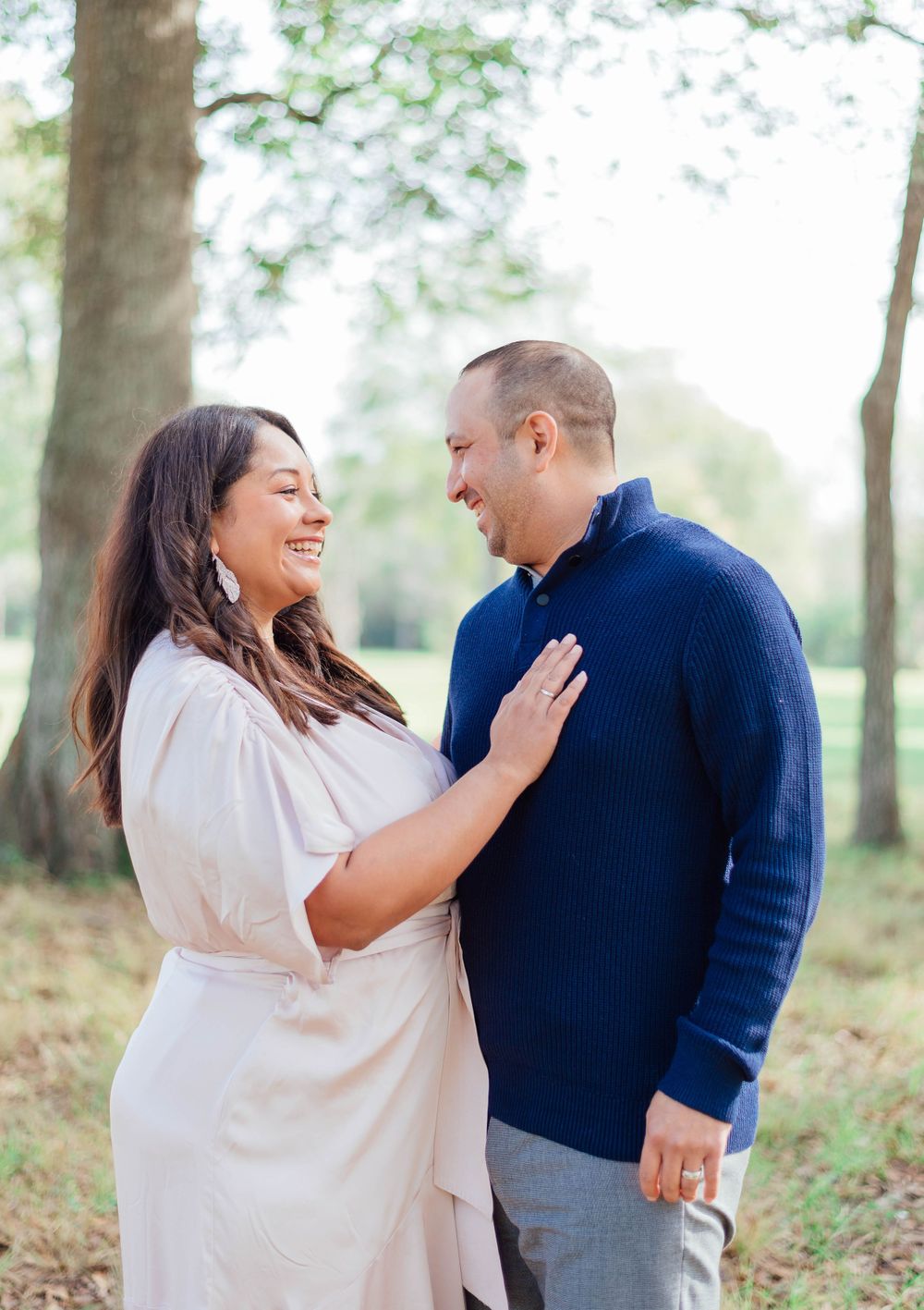 A couple shares a joyful moment together during their outdoor photo session in casual elegant attire.
