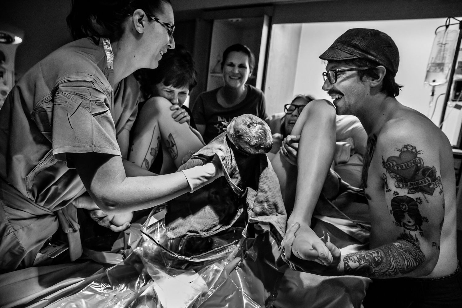 Black and white image of medical professionals working on a patient with tattoos.