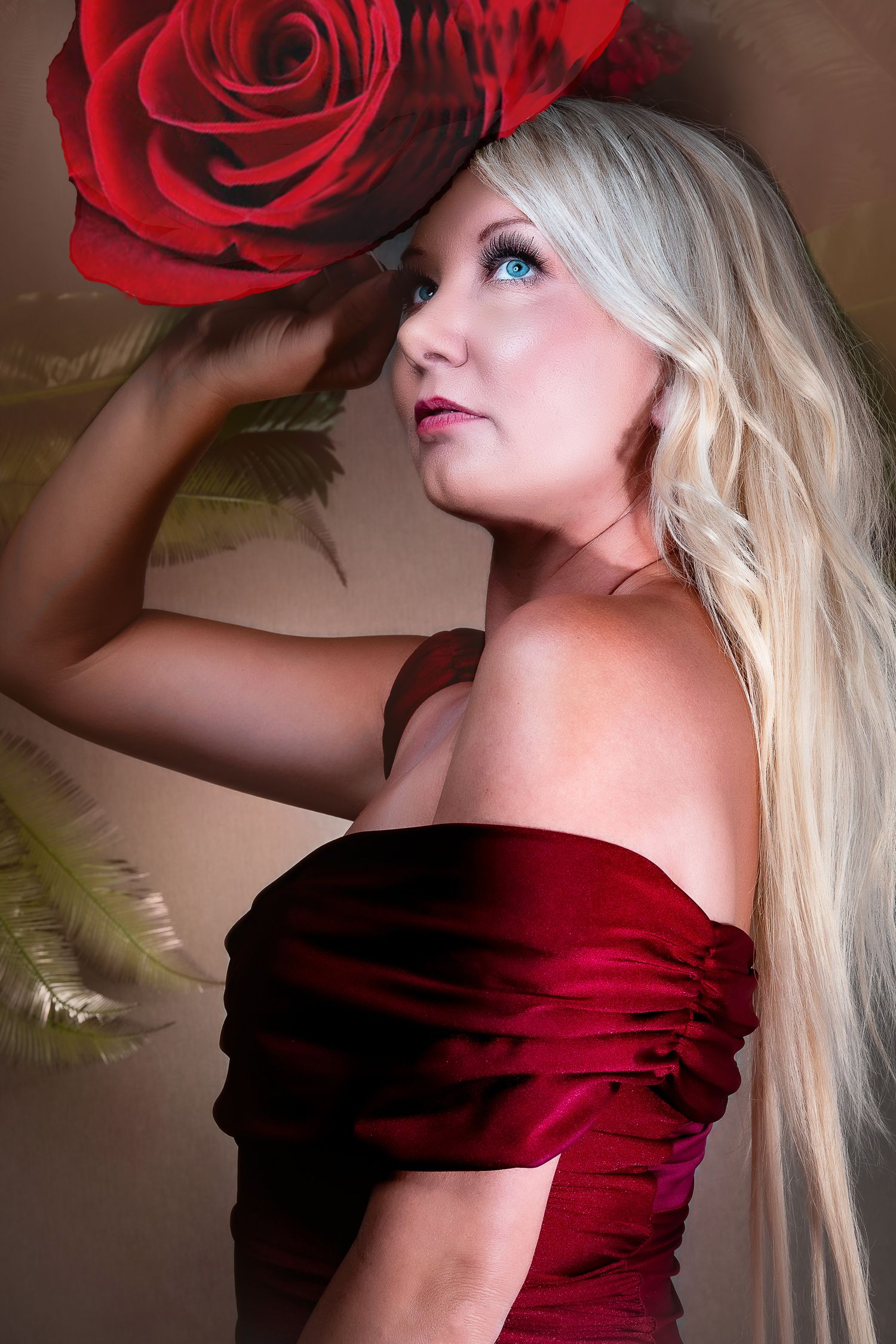 Artistic portrait with red rose and blonde hair against dramatic lighting.