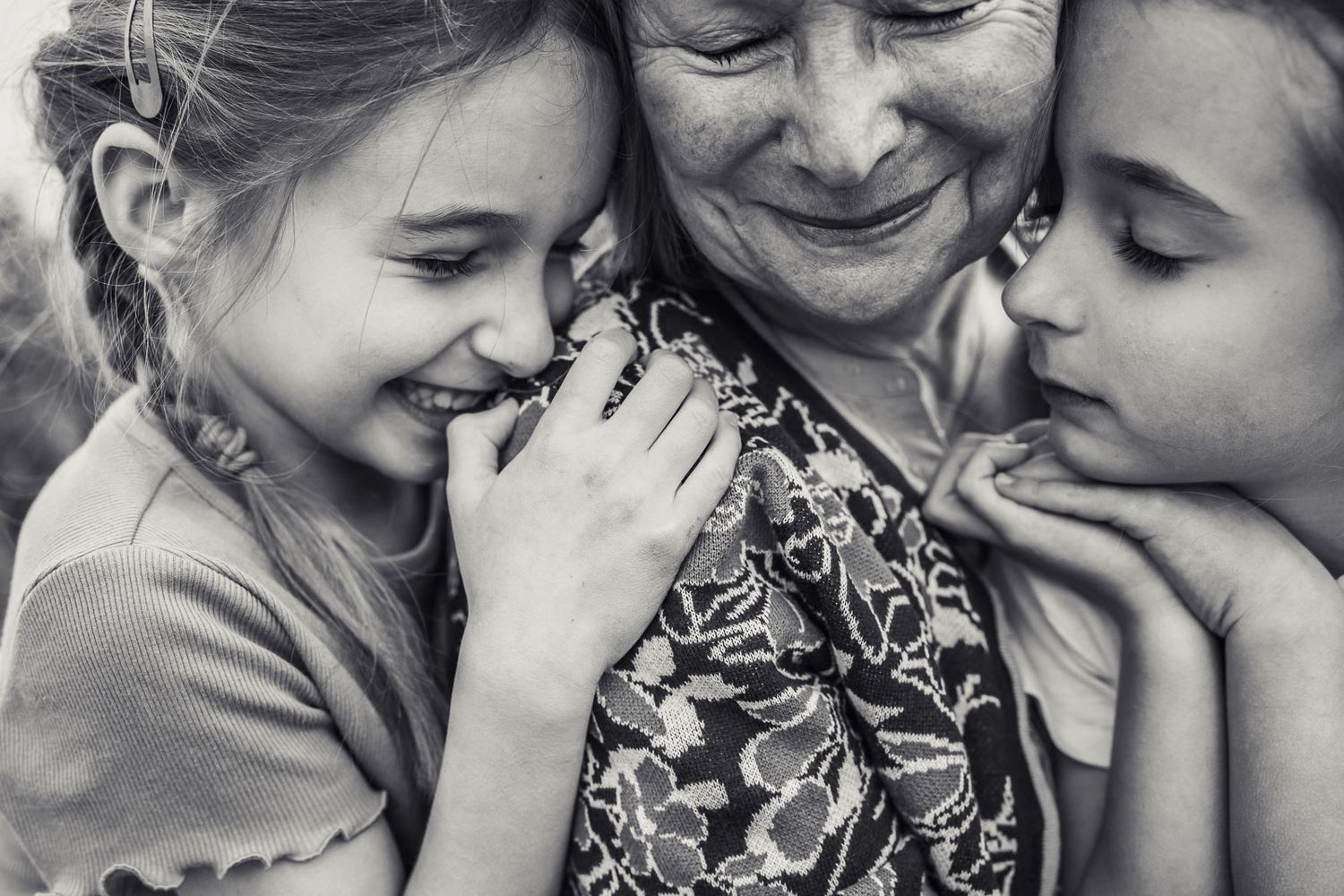 Black and white photo of grandmother smiling with grandchildren.