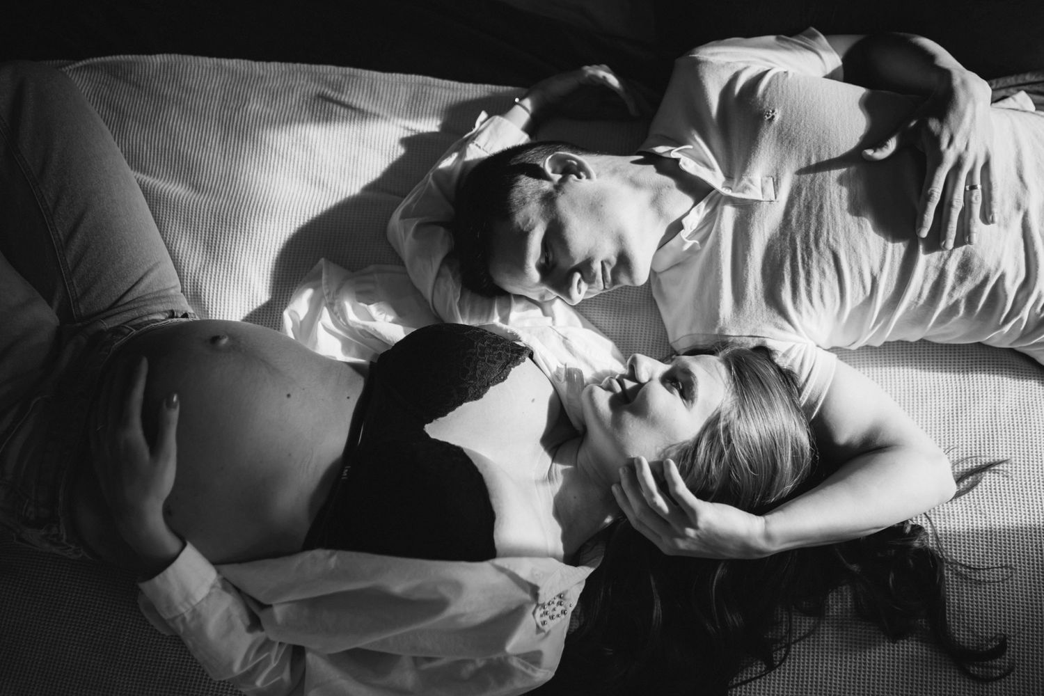 Black and white intimate portrait of couple lying together.