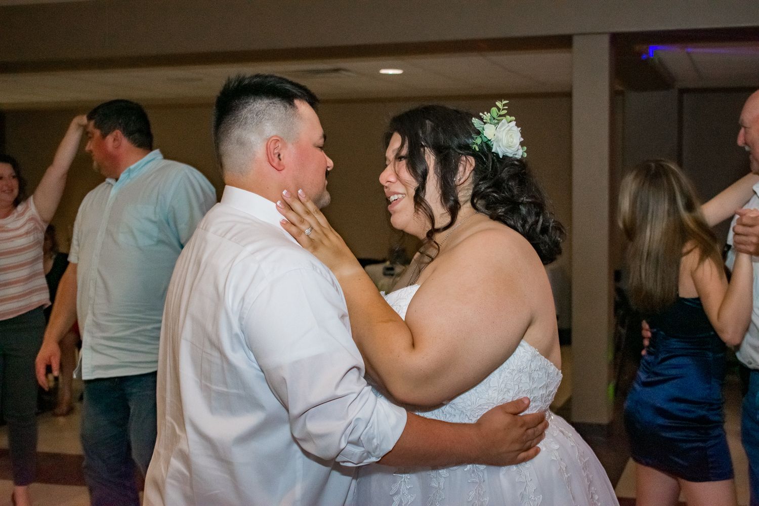A tender moment shared during a wedding dance in a reception hall.