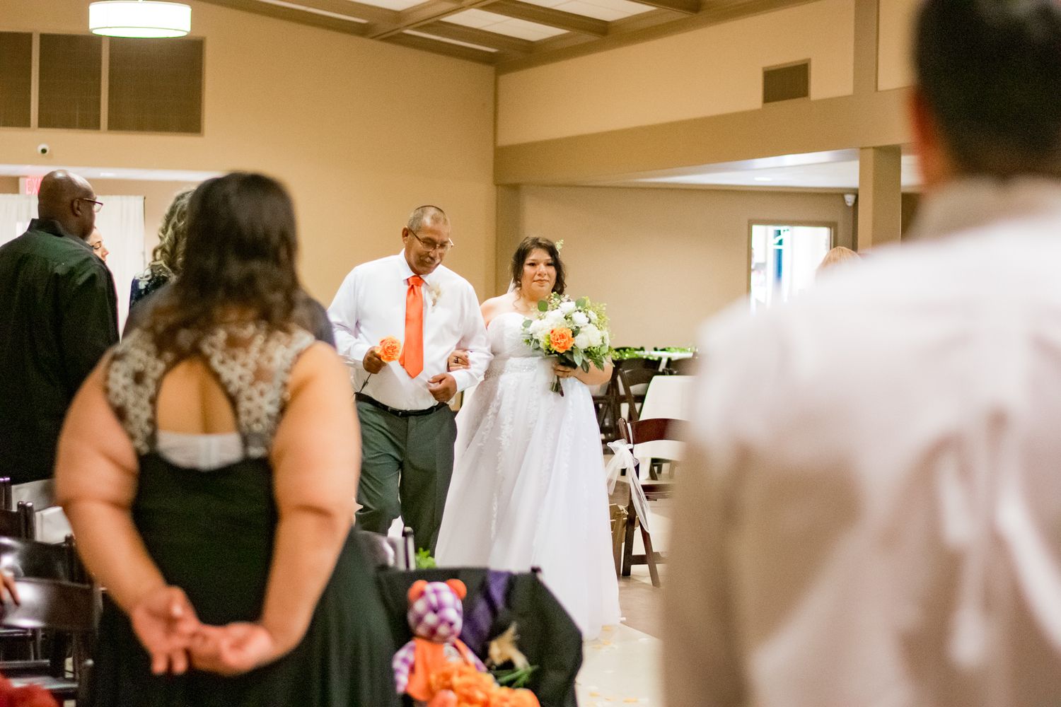 Wedding ceremony in progress with guests seated in church venue.