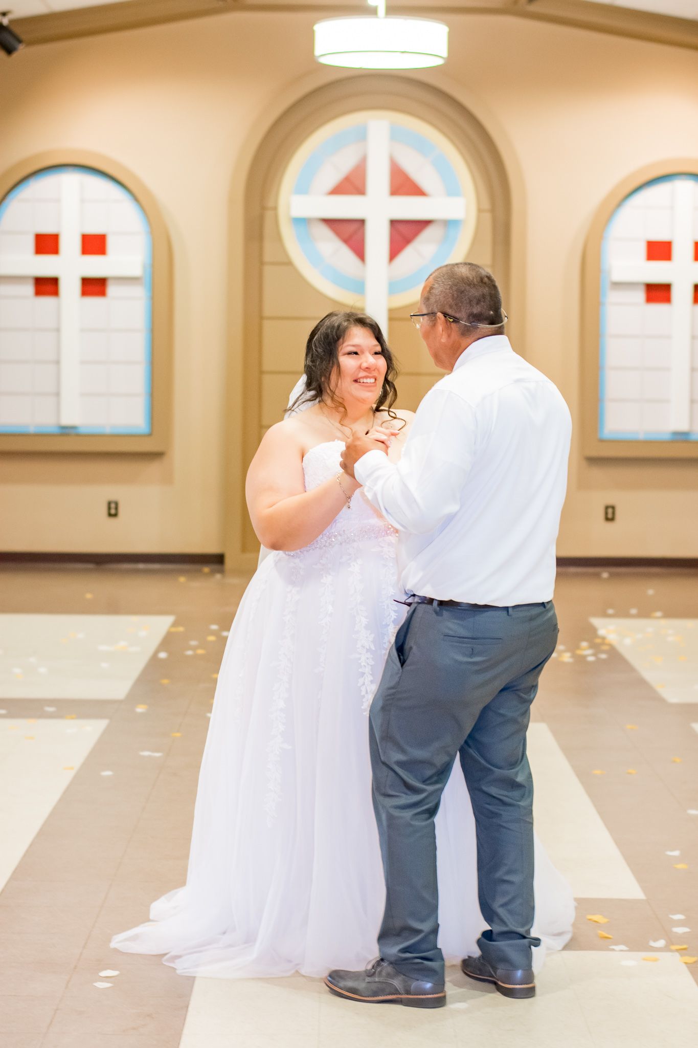 Intimate dance moment during wedding reception in church hall.