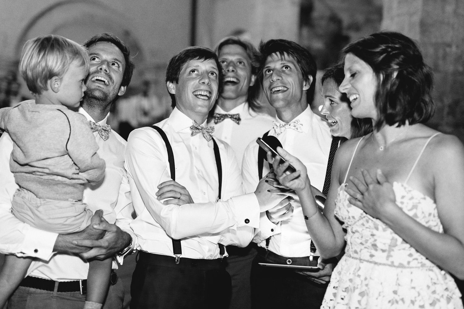 A black and white photo of wedding guests enjoying themselves at a reception party.