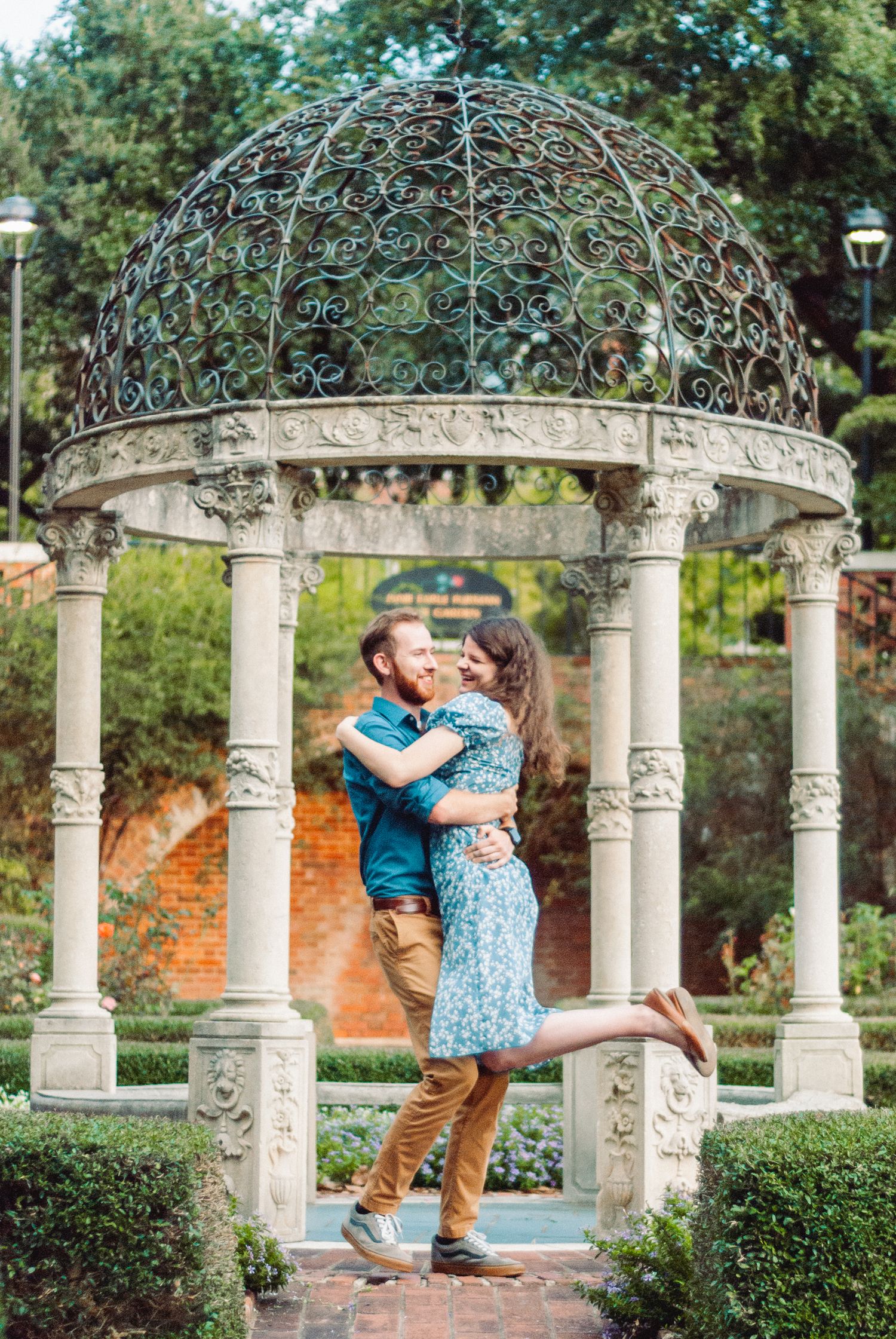Couple spinning after engagement in a rose garden at Furman university in Greenville, South Carolina