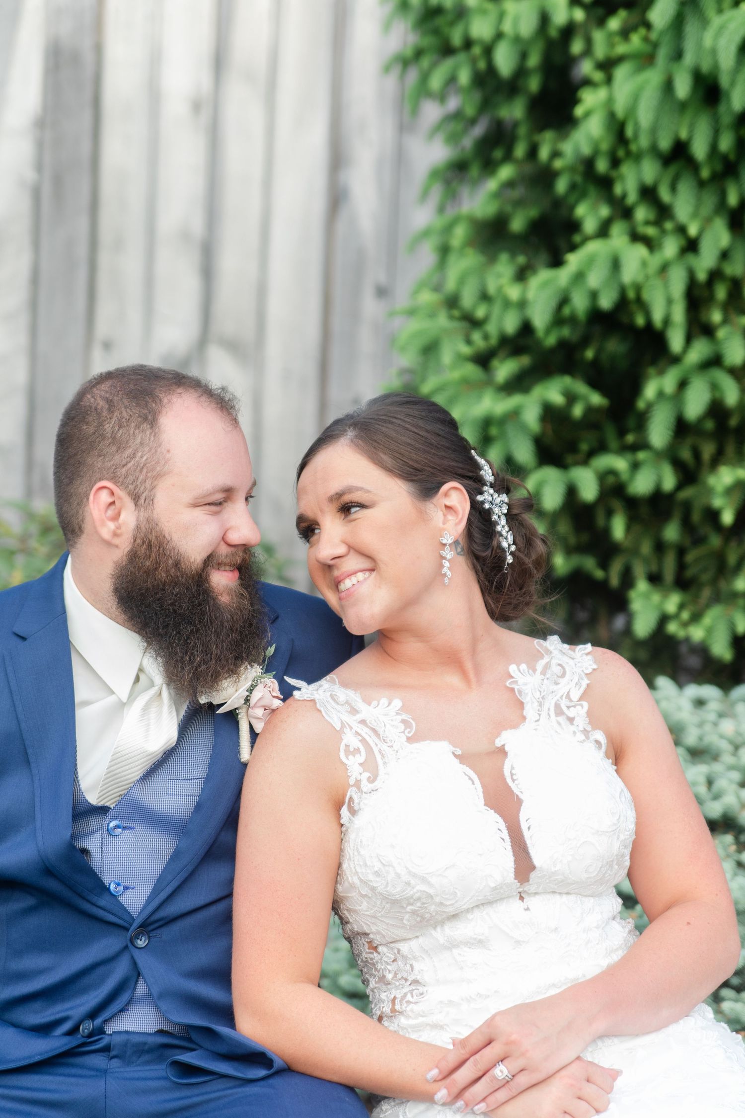 Candid wedding portraits showing joyful moments between newlyweds against a garden backdrop.