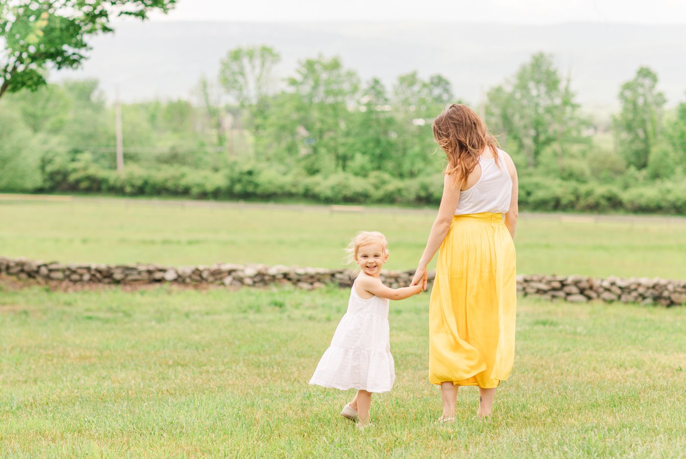 Mother and daughter walking towards mountains during a photo session with Danielle Lauren Photography