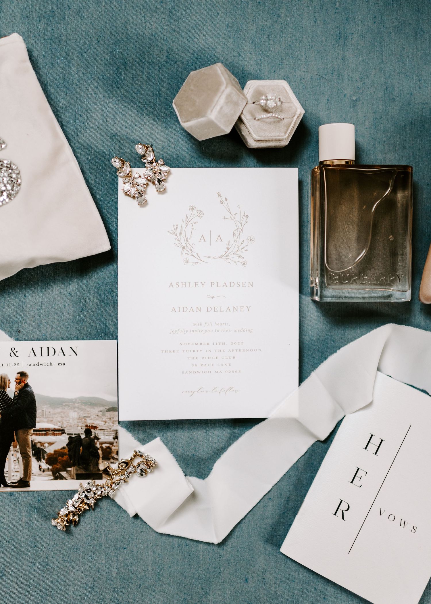 Wedding invitation suite with modern typography and elegant details on teal surface.