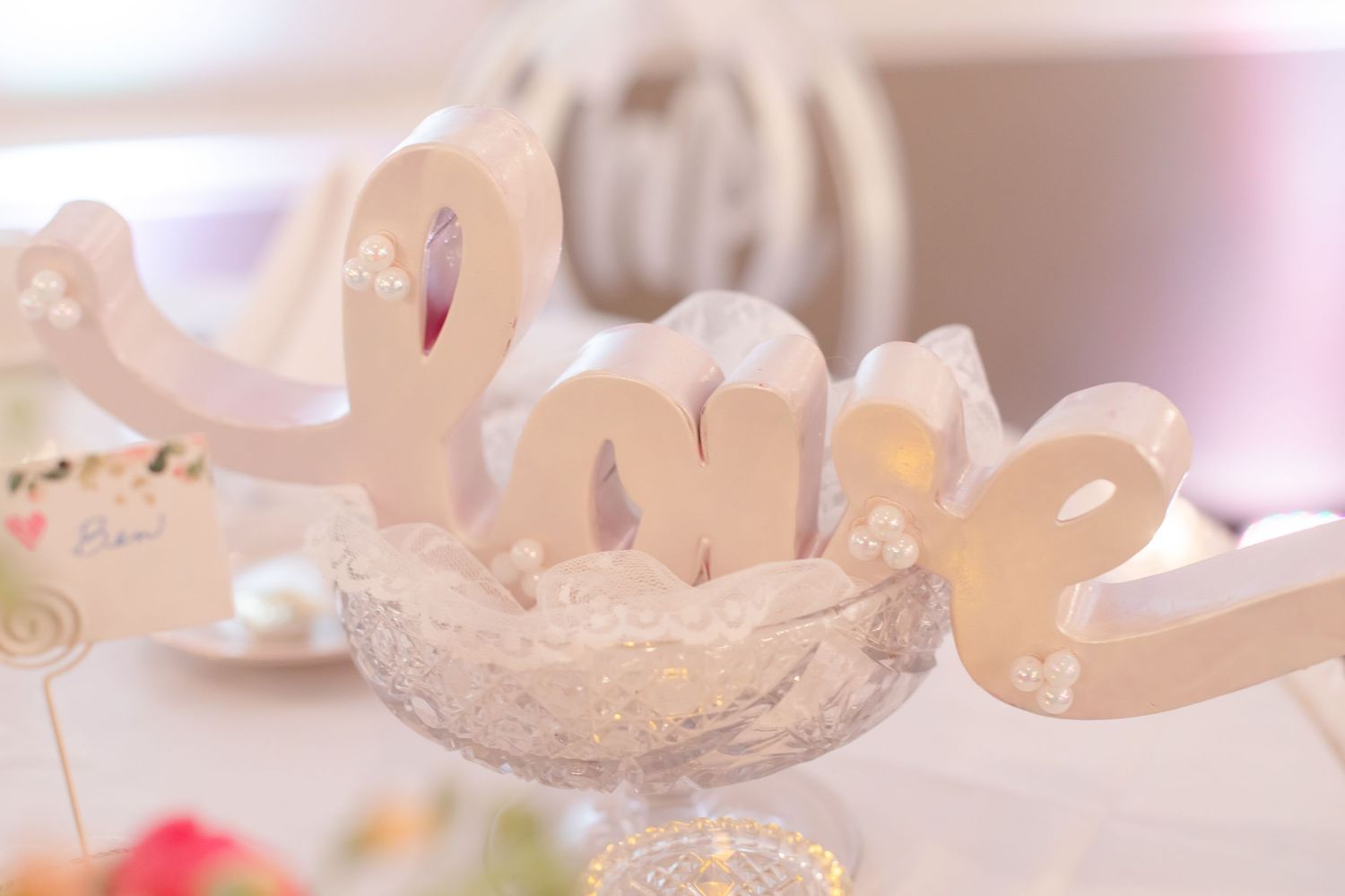 Decorative white wedding signage and decor elements with soft lighting effects.