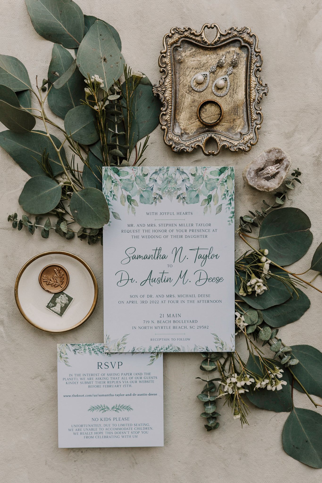 Wedding invitation with eucalyptus leaves and vintage styled details on light background.