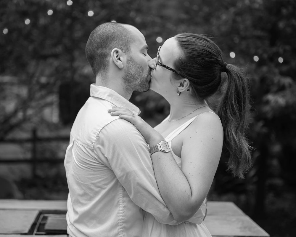 Black and white romantic portrait of a couple sharing an intimate kiss.