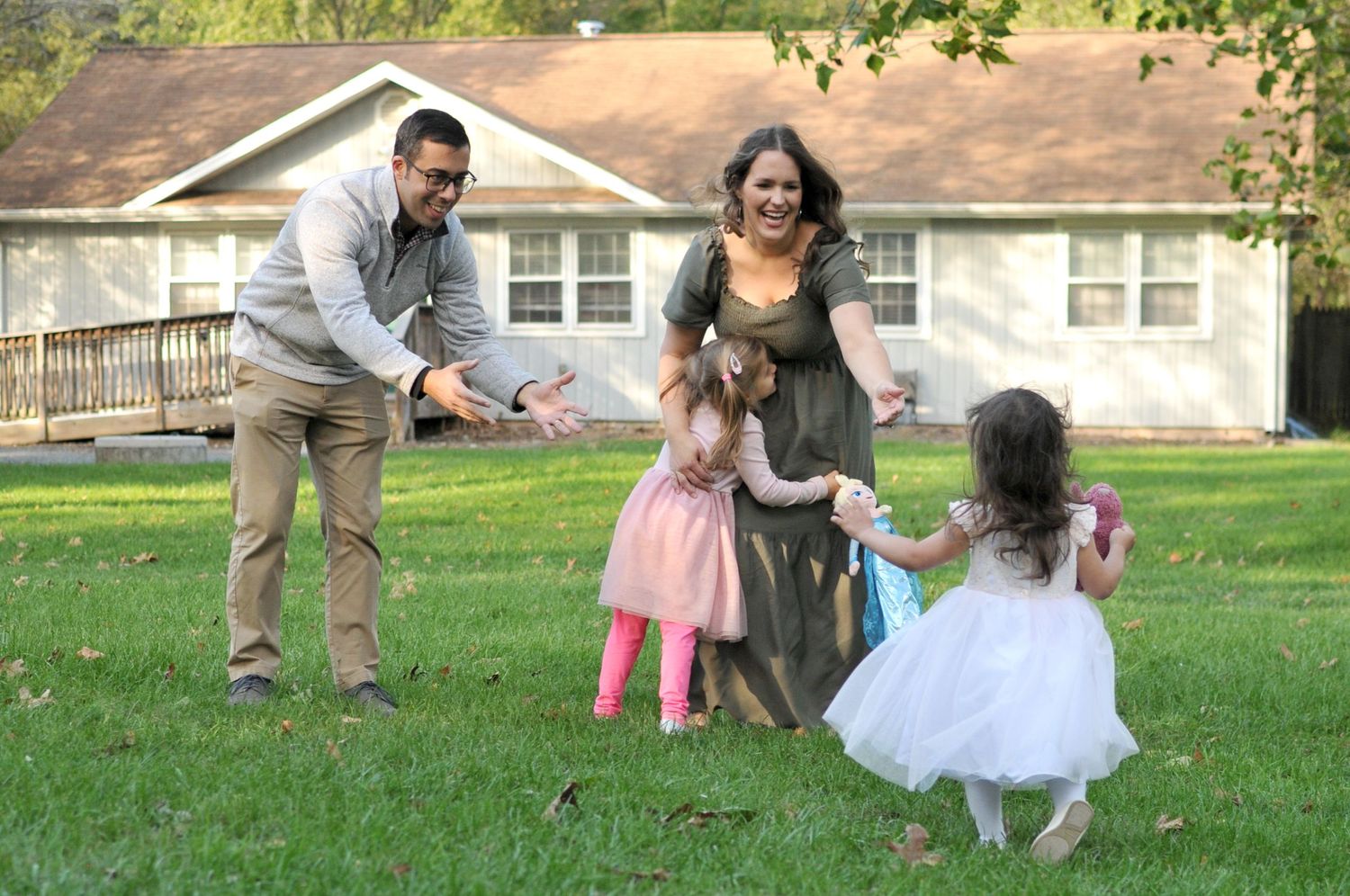 Family photo candid with girls running to parents