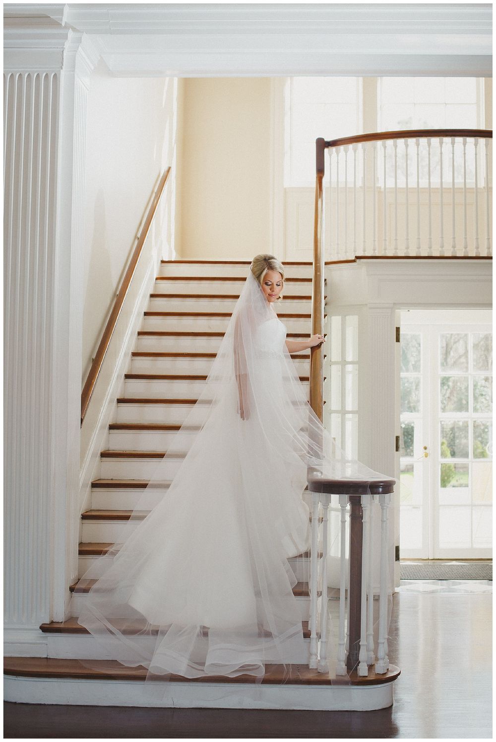 Ethereal bridal portraits on classic wooden staircase with flowing veil and natural light.