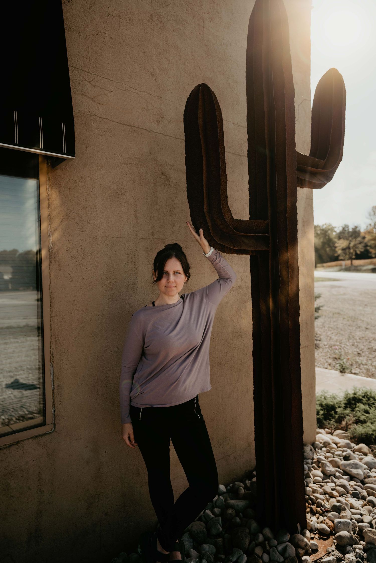 photographer Silvie leaning on iron art work cactus