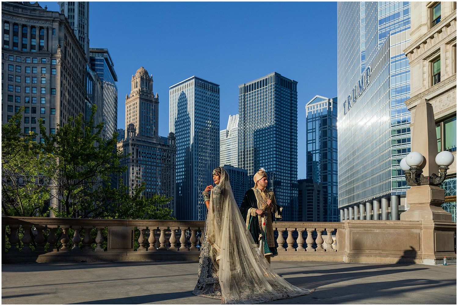 Couple in formal wear photographed against dramatic Chicago skyline backdrop.