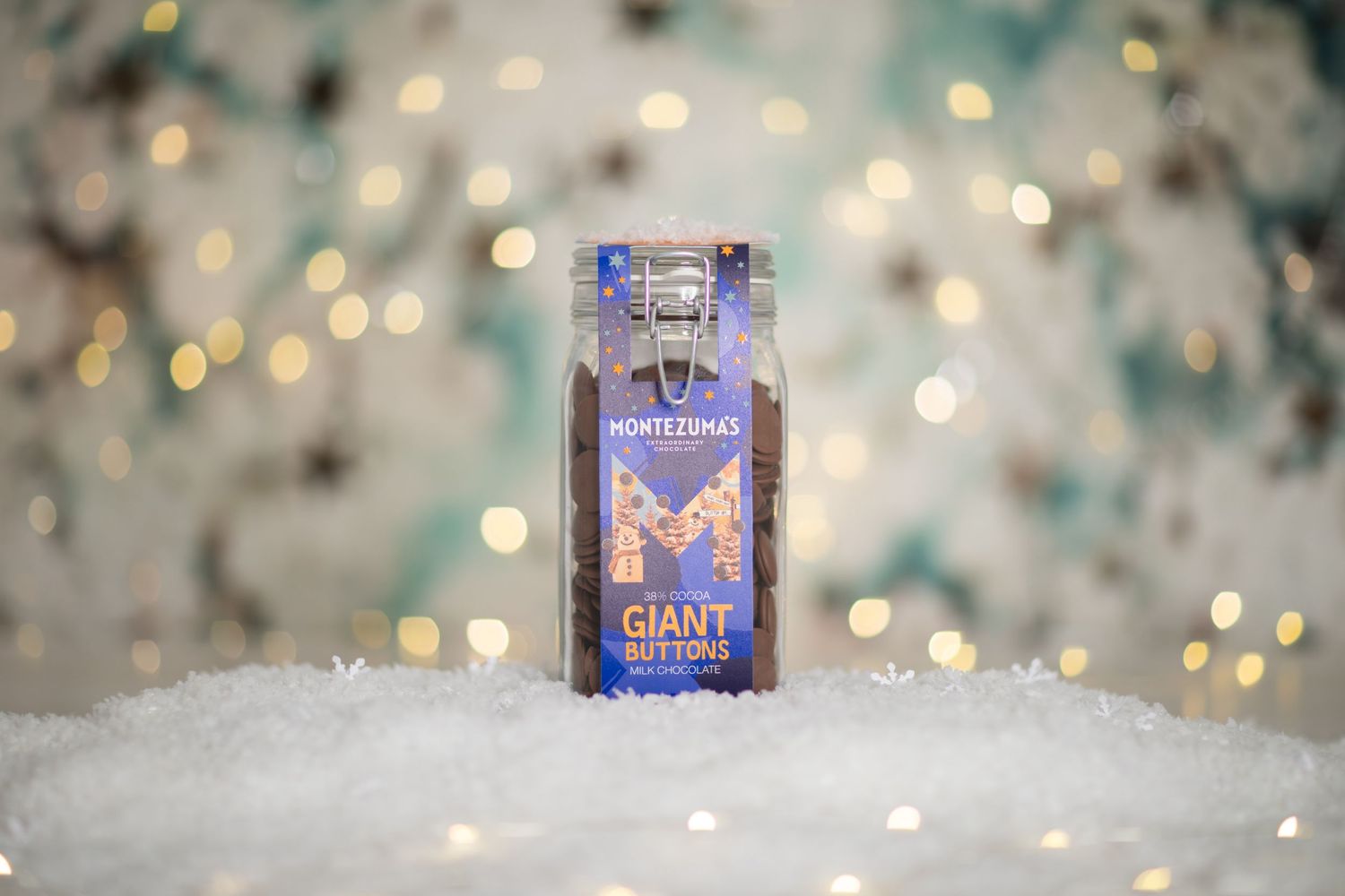 Holiday themed product photography of a metallic blue gift box on sparkling snow background.