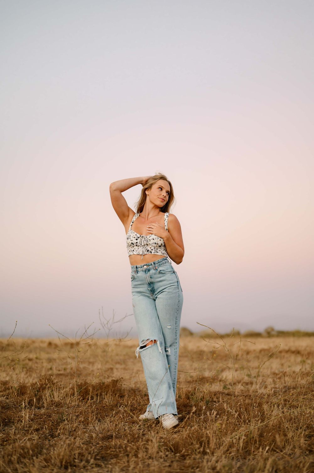 Ojai high school senior portrait by Ventura and Camarillo portrait photographer of girl in golden grass field wearing jeans and crop top
