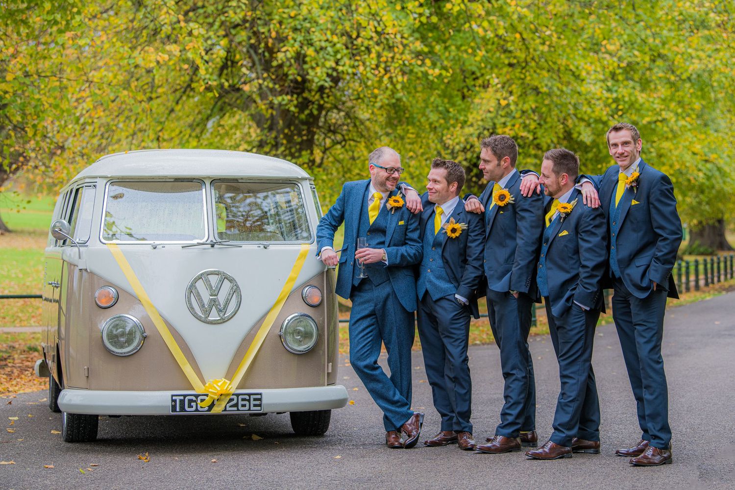 groomsmen leaning on each other against a camper van, at Delapre Park, Northampton