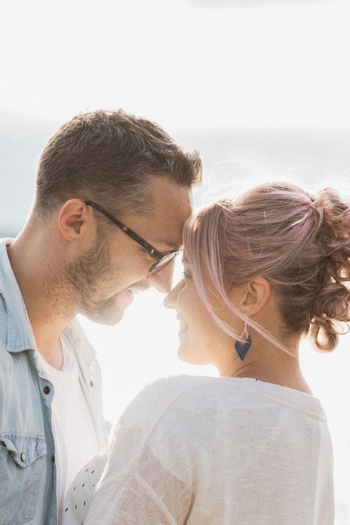 Intimate close-up of a couple sharing a tender moment in soft natural light.