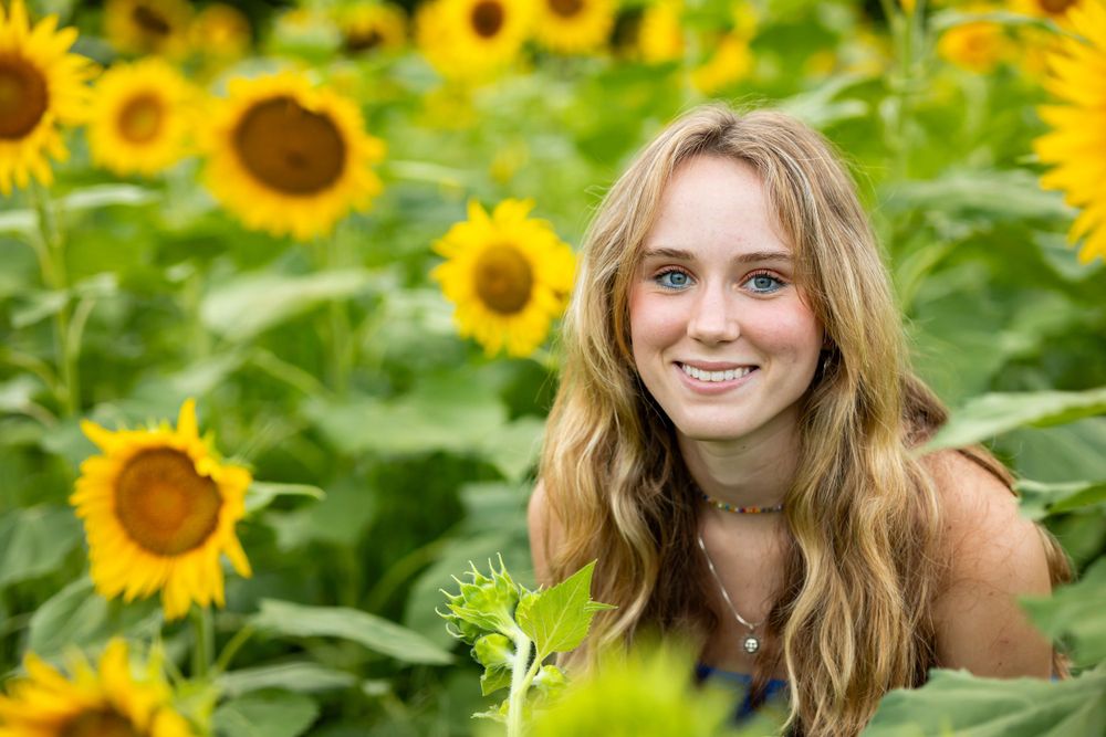 Summer portrait amidst blooming sunflowers with natural lighting.