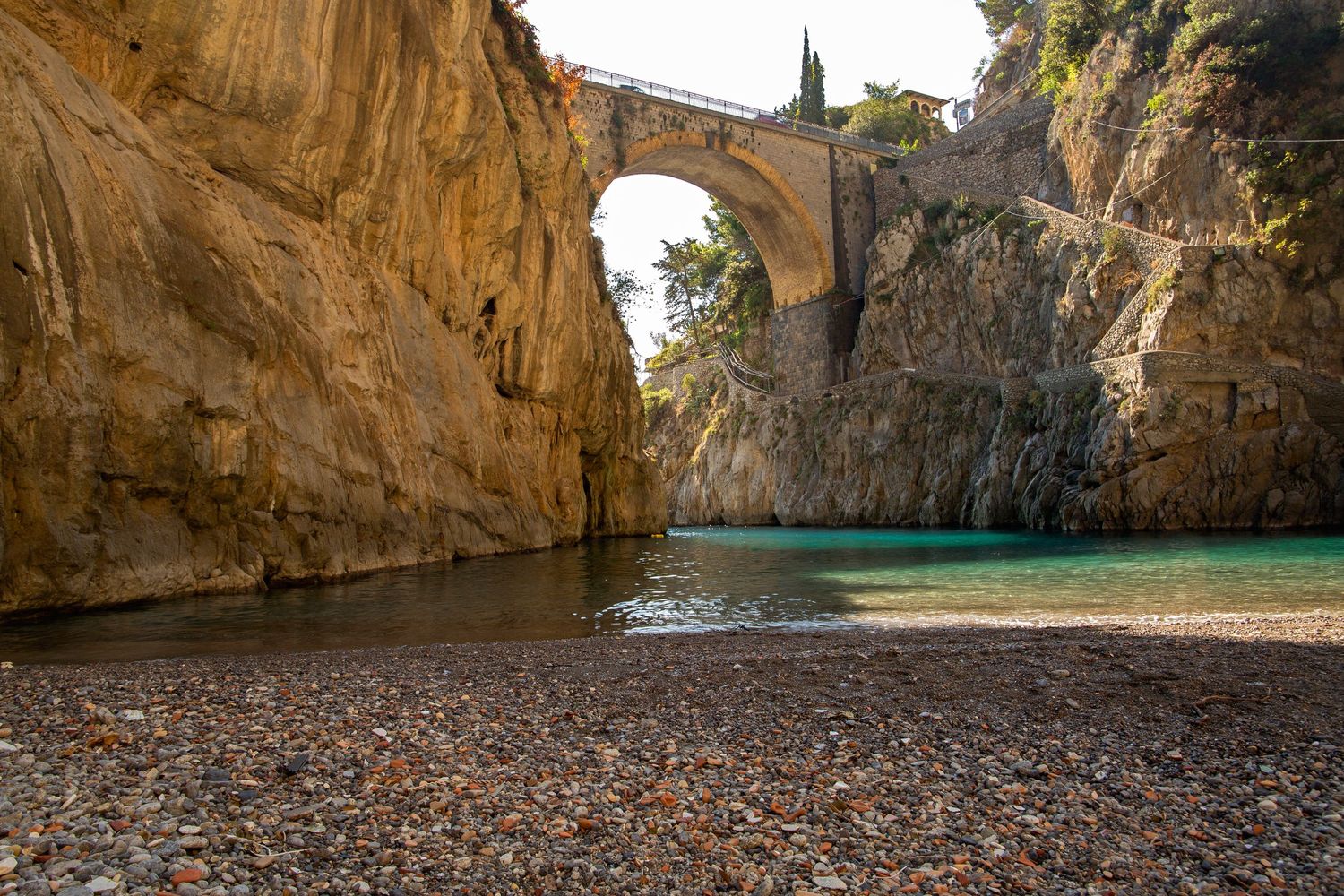 photo of lake in italy under a bridge blue water