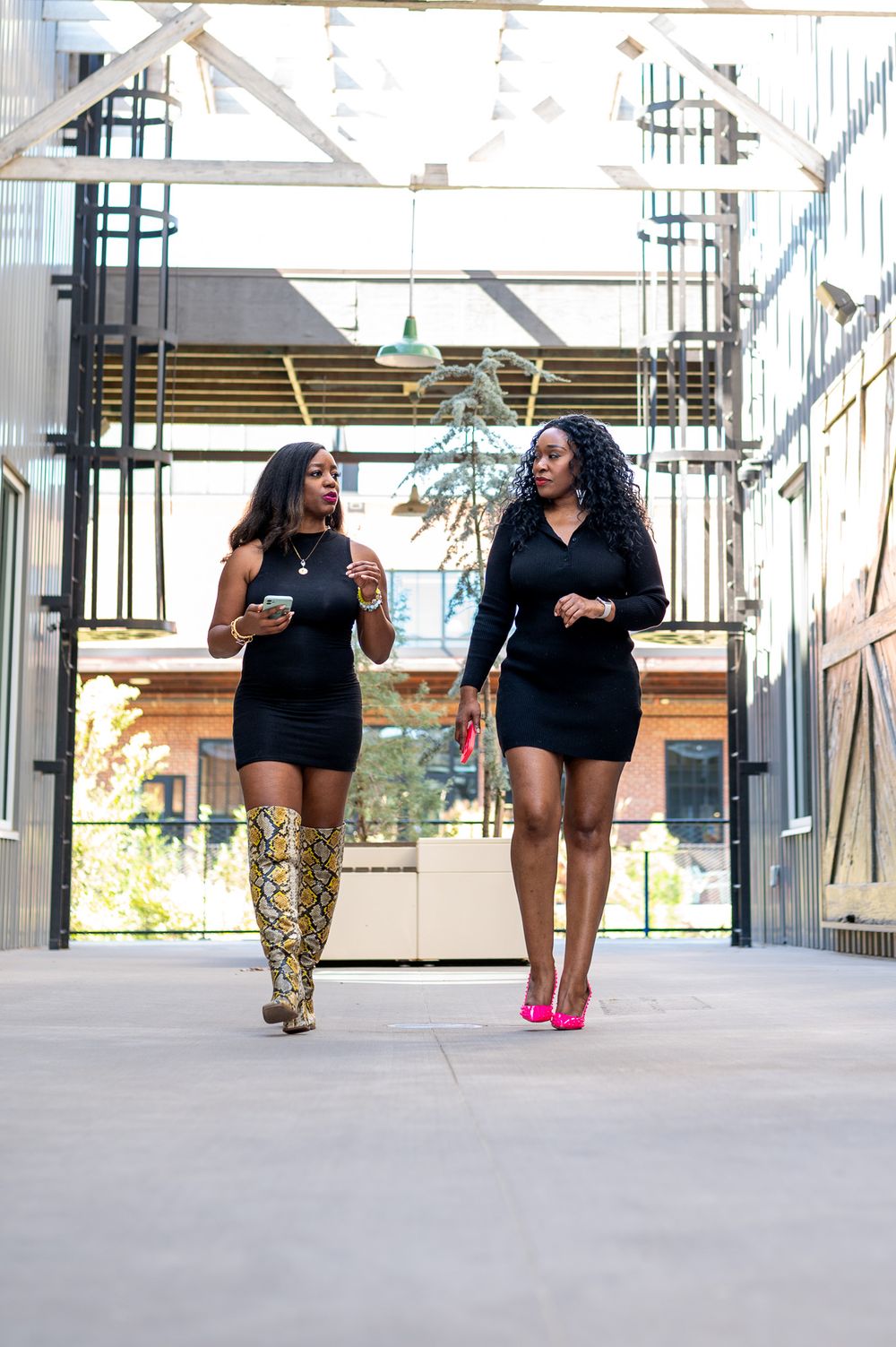 Two women walking together outdoors, engaged in a business discussion.