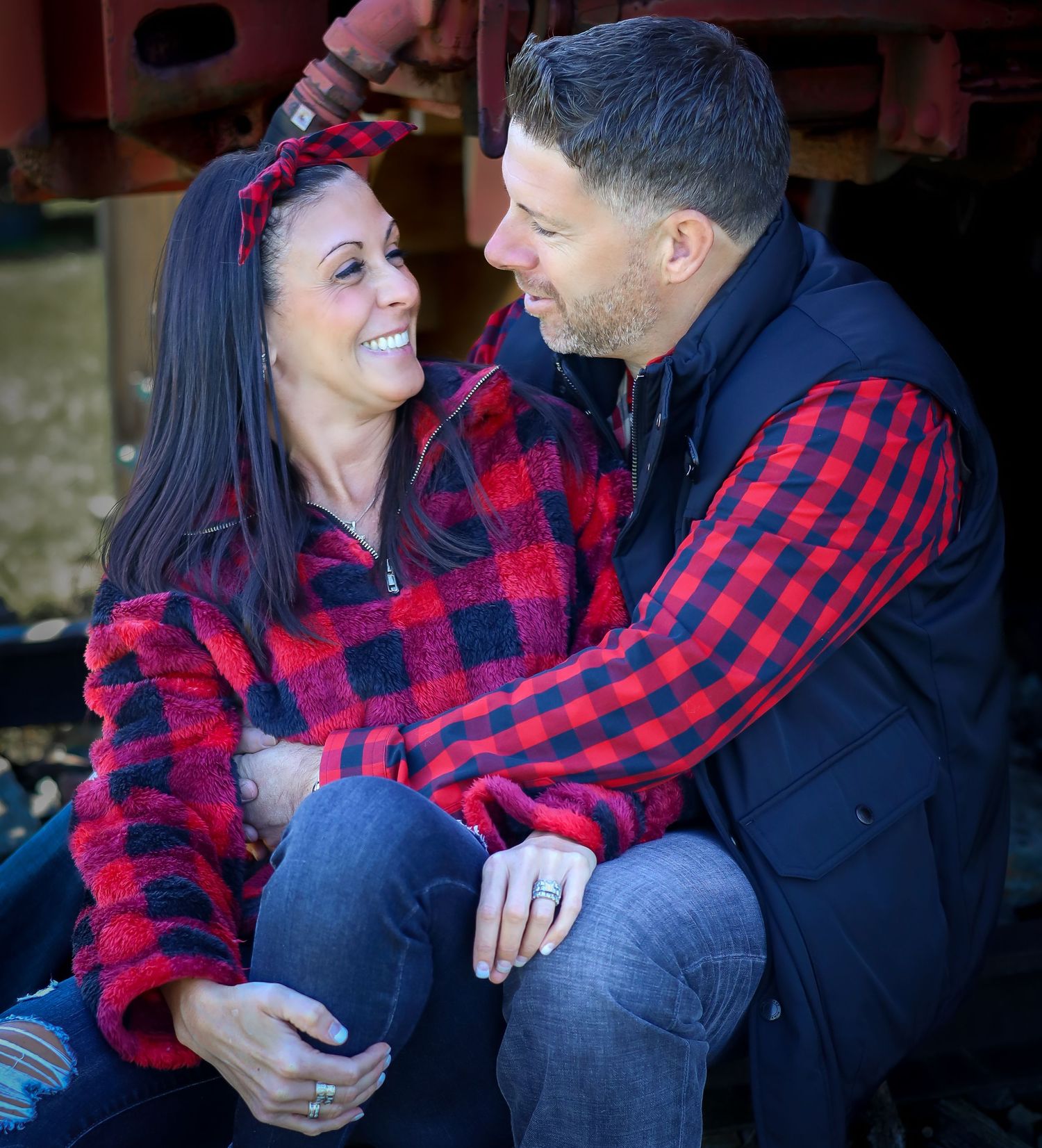 Couple in matching buffalo plaid sharing intimate moments outdoors.