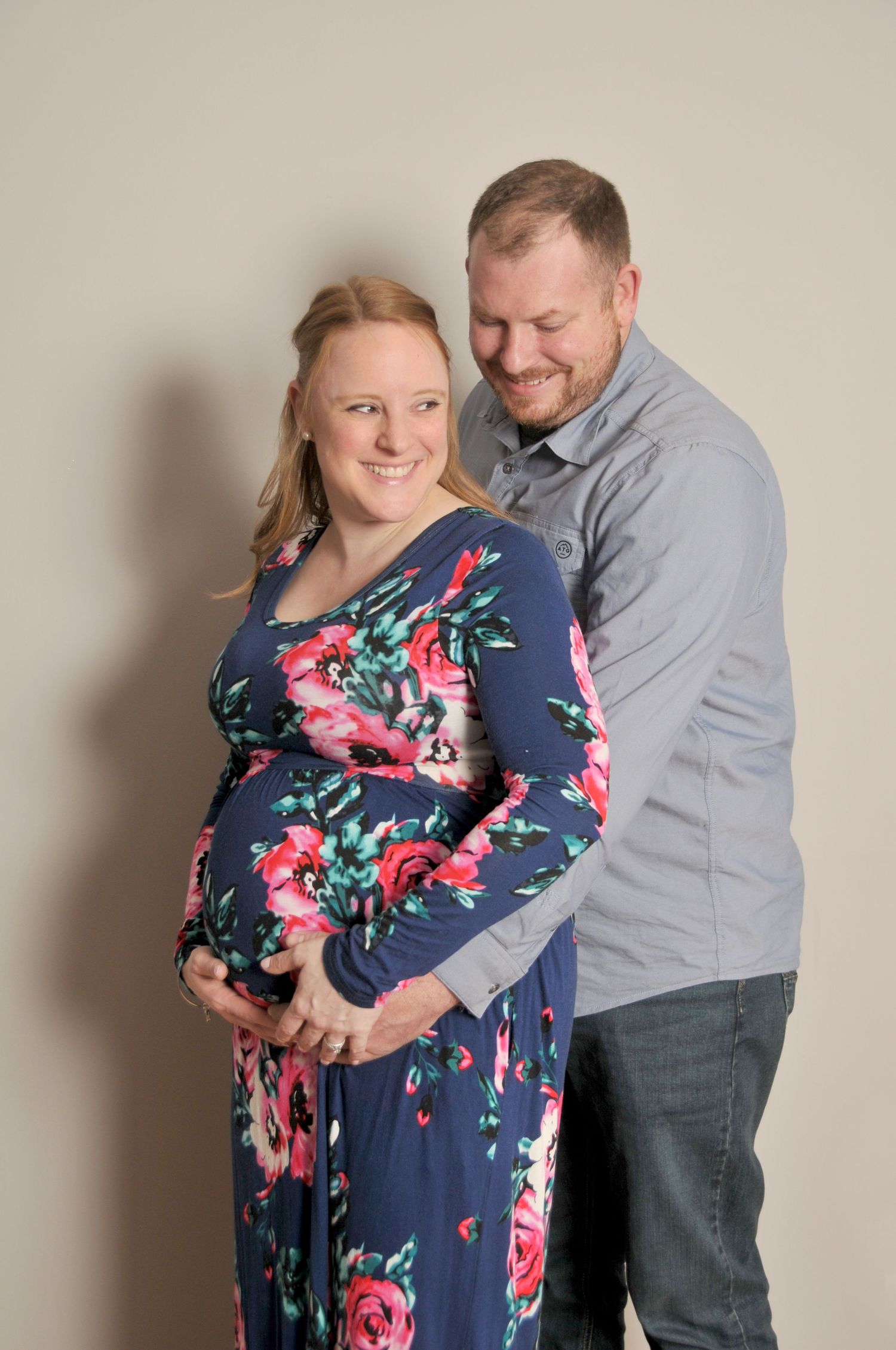 laughing maternity photo parents indoors