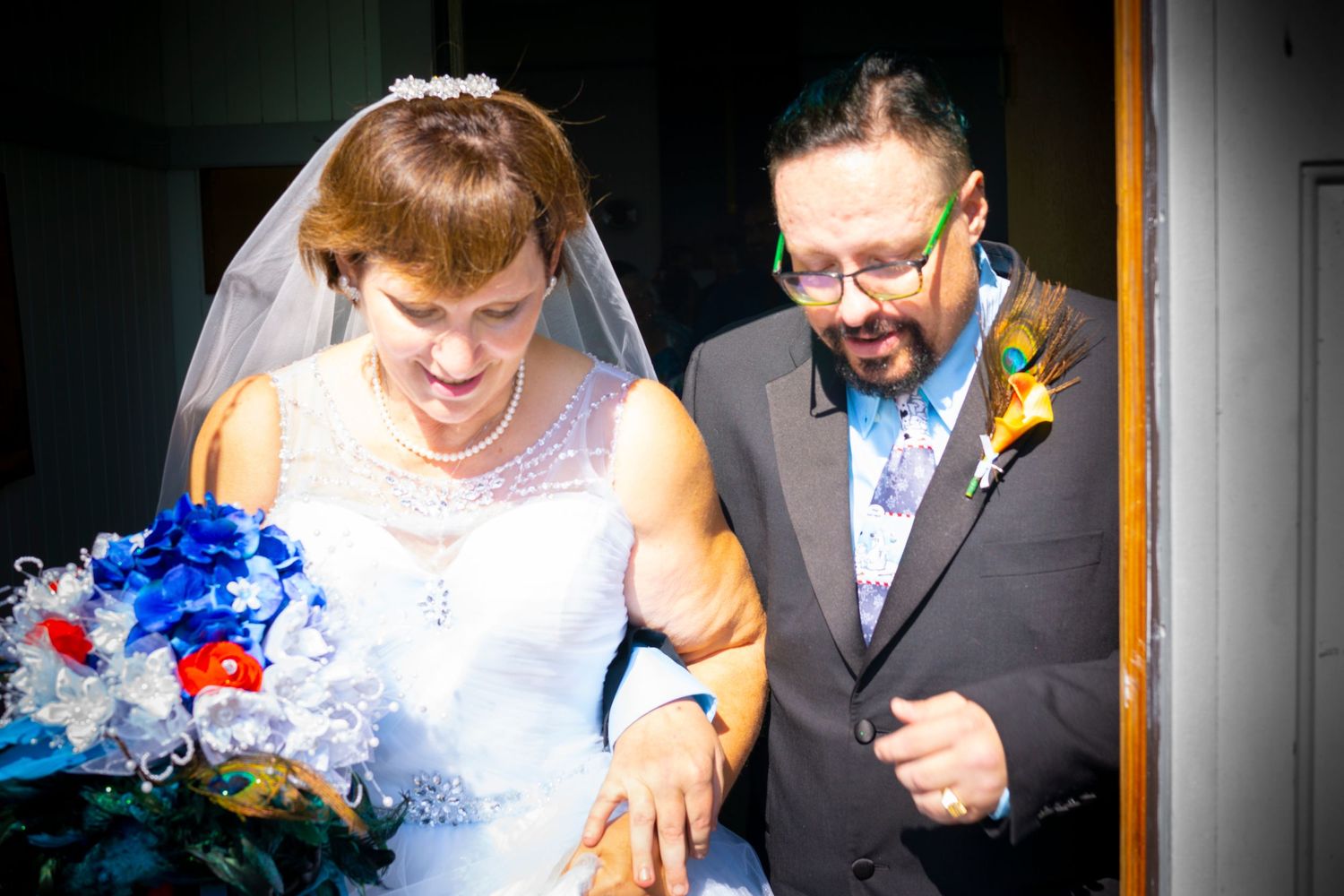 A joyful wedding moment captured with blue bouquet details.